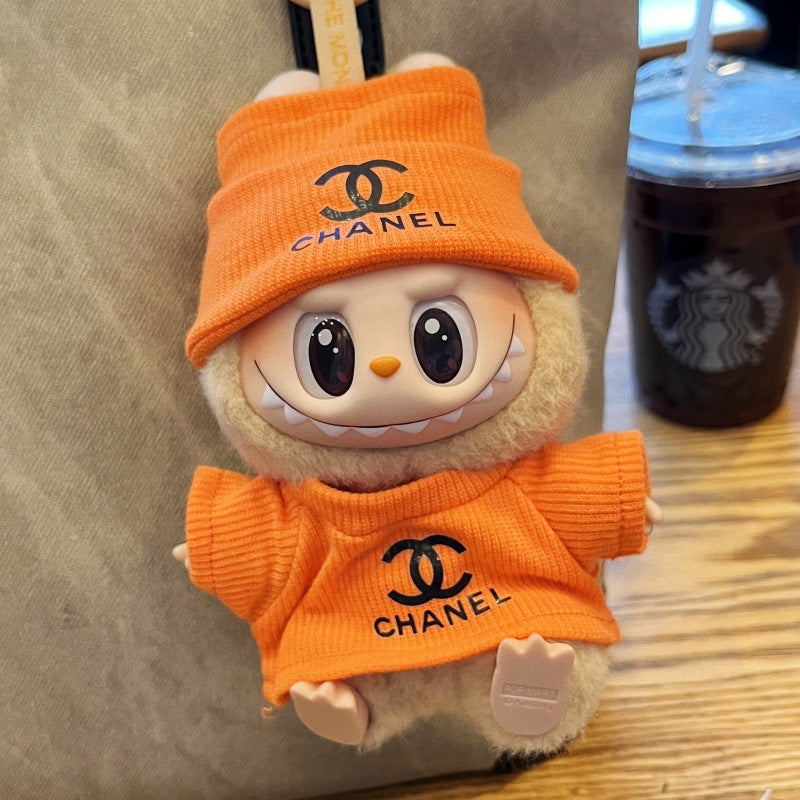Labubu doll wearing orange Chanel-style dress and hat